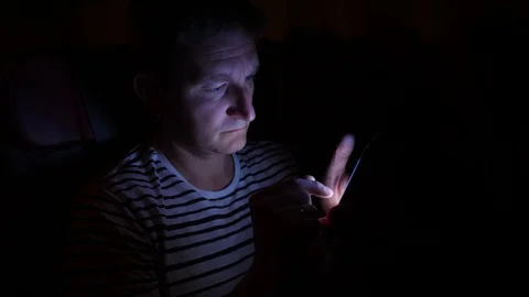 Man is flying by the plane at night. he flips pages of document in his phone 库存影片 97189197