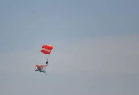 A Man is Flying in the Sky by using IAF Parachute in Airshow for Indian Air.. Foto stock