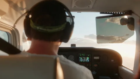 Man flying a small Cessna airplane during the sunrise. Stockbeeldmateriaal 164318092
