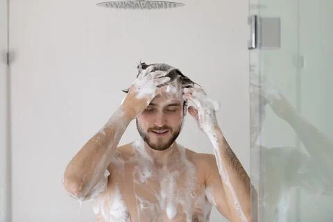 Man with foamy head and body taking a shower Stock Photos