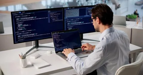 Man Focused On Coding Laptop, Developing Web Project In Modern Office. Foto stock