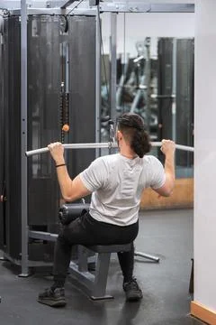 Man in focused lat pulldown workout at a gym. Foto stock