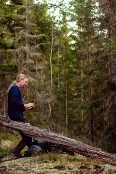 Man focused on smart phone in the forest Stock Photos