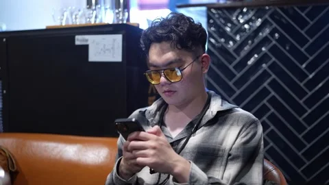 Man focused on smartphone at bar table Stock Footage 346304591
