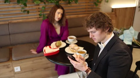 Man focused on smartphone during cafe date ignoring woman and real Video stock 328284428