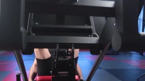 Man focused on training legs on the machine in the gym Stock Footage 73230824