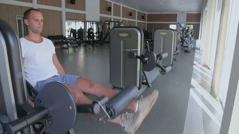 Man focused on training legs on the machine in the gym Stock-Footage 82107588