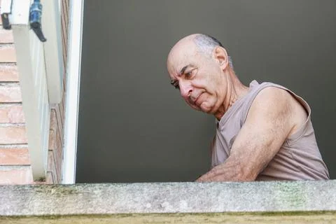 Man focuses on task while standing by balcony Stock Photos