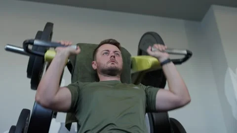 Man focusing on his workout, engaging muscles while lifting weights at fitness c Stock-Footage 339597979