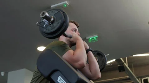 Man focusing on strength training using a barbell at the gym Stock-Footage 339598680