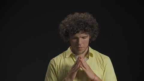 Man folded his hands in a plea and closed his eyes. He hopes and guesses Stock Footage 139470295
