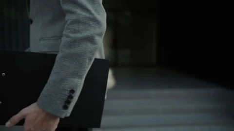 A man with a folder and pen walks along the building Stock Footage 113471335