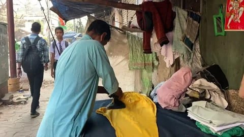 Man folding clothes at a street-side makeshift shop Stock Footage 306684394