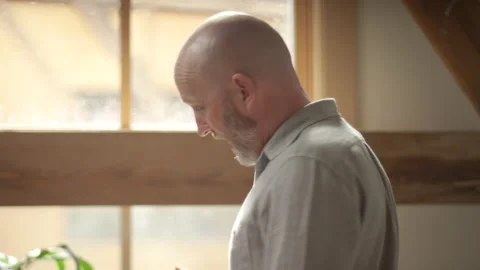 Man folding laundry while video chatting with a coworker Video stock 133292988