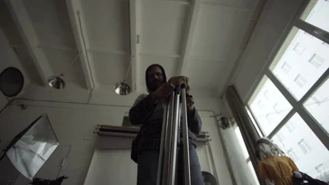 Man folds a tripod in case Stock Footage 72104283