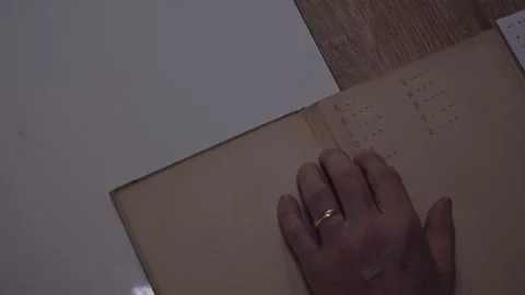 Man following reading morse code dictionary old book hand with golden ring Vídeos de archivo 236545916