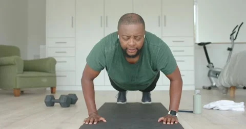 Man following workout routine, doing push-ups on yoga mat in bright studio, Stock Footage 336484205