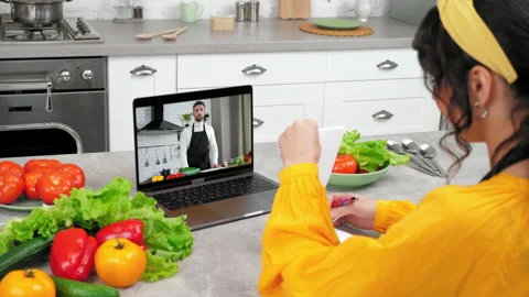 Man food blogger in computer screen greets tells teaches housewife online webcam Stock Footage 221124893