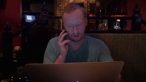 The Man in the Foot-Block is Having Supper in a Cafe and Working Behind a Stock Footage 73493228