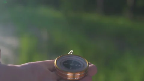 A man in the forest with a compass in his hand on a sunset background Stock Footage 134801780