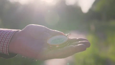 A man in the forest with a compass in his hand on a sunset background Stock Footage 134801789