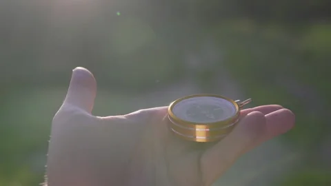 A man in the forest with a compass in his hand on a sunset background Stock Footage 134801801