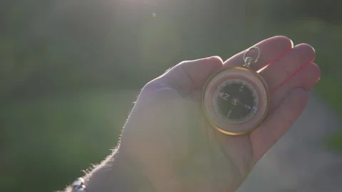 A man in the forest with a compass in his hand on a sunset background Stock Footage 134801874