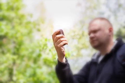 A man in the forest with a navigator in his hand. Location determination. The Stock Photos