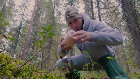 A man in the forest really wants to go to the toilet and grabs toilet paper. Stock Footage 320018621
