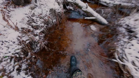 A man in the forest walks through the water in a narrow stream. Stock Footage 321357688