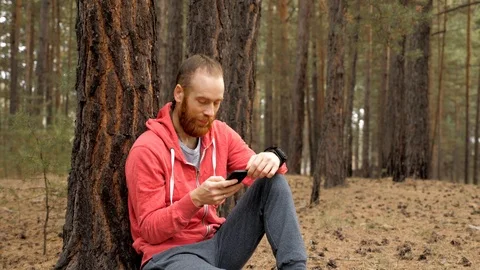 Man in the forest is watching a smartphone. Stock Footage 98073641