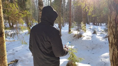 The man in a forest in winter holds a bottle of pure water. Stock Footage 105103153