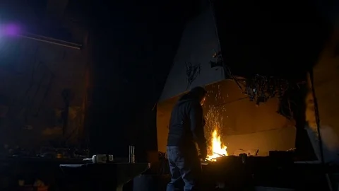 Man forges metal in the forge Stockbeeldmateriaal 69857636