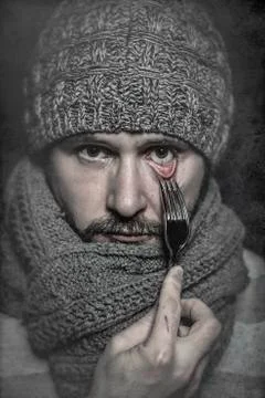 Man with a fork in his eye, concept danger, risk 스톡 사진