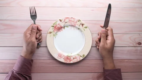 Man with fork, knife and empty plate on wooden table. Stock Footage 133808234