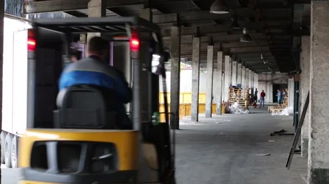 Man on a fork loader unloads goods from auto truck. Stock Footage 45873928