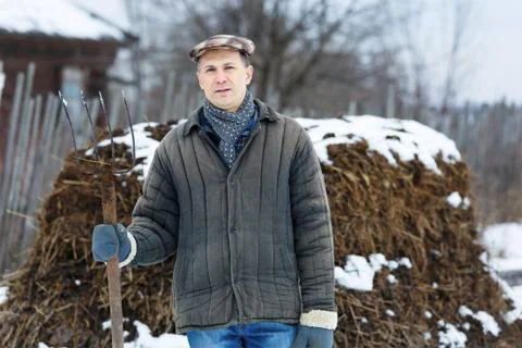 Man with fork in of manure early spring Stock Photos