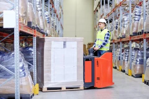 Man on forklift loading boxes at warehouse Stock Photos