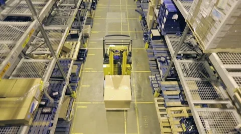 Man on forklift riding between racks in warehouse. Vídeo Stock 61136187