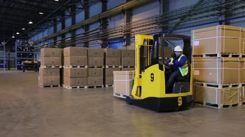 Man on forklift transporting cargo from one storage to another Stock Footage 61123324