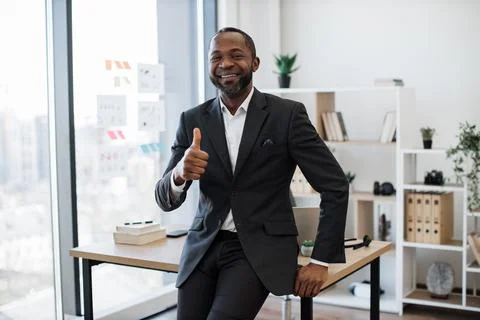 Man in formal attire smiling at camera at office Stock Photos