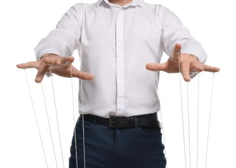 Man in formal outfit pulling strings of puppet on white background, closeup Stock Photos