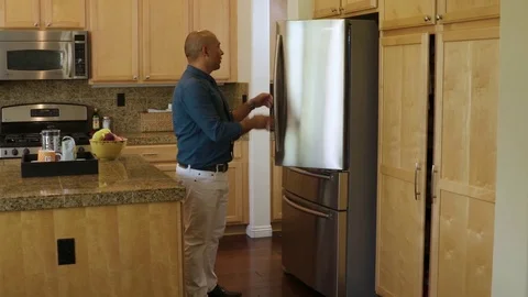 Man in formals checking his refridgerator in the kitchen Stock Footage 83188082
