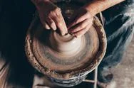 Man Forms A White Clay Product On A Pottery Wheel Top View.. Stock Photos