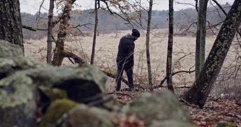 Man in a Forrest Throwing Stones Stock Footage 124701061