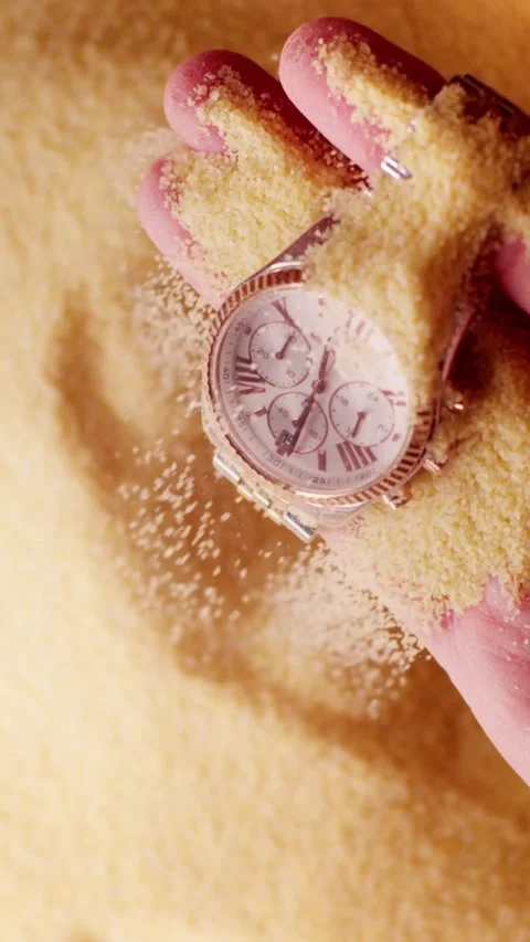 A man found a clock in the desert, yellow sand is pouring, revealing details 動画素材 237701641
