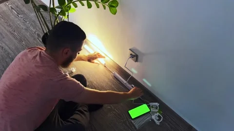 The man found the instructions on the Internet and is guided by it to connect th Stock Footage 254880618