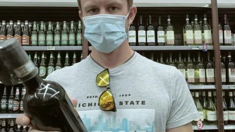 Man Found a Red Wine at Store While Wearing a Mask During Covid-19 Pandemic Stock Footage 140927050