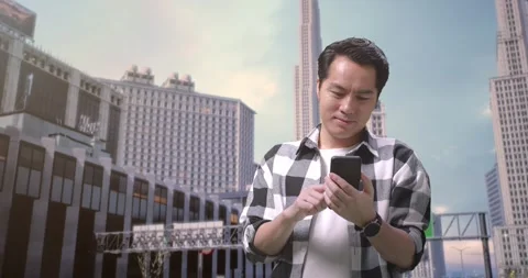 Man Freelancer Using Smartphone While Standing In Front Of Buildings Working Video stock 245287831