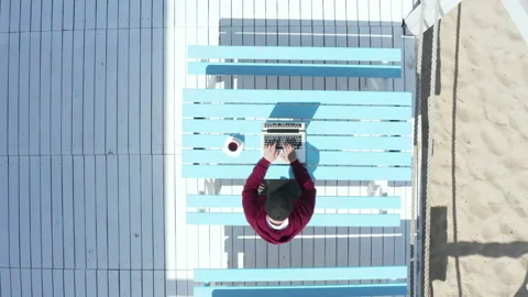 Man freelancer working on a laptop while sitting in a cafe on vacation. Stock Footage 198333841